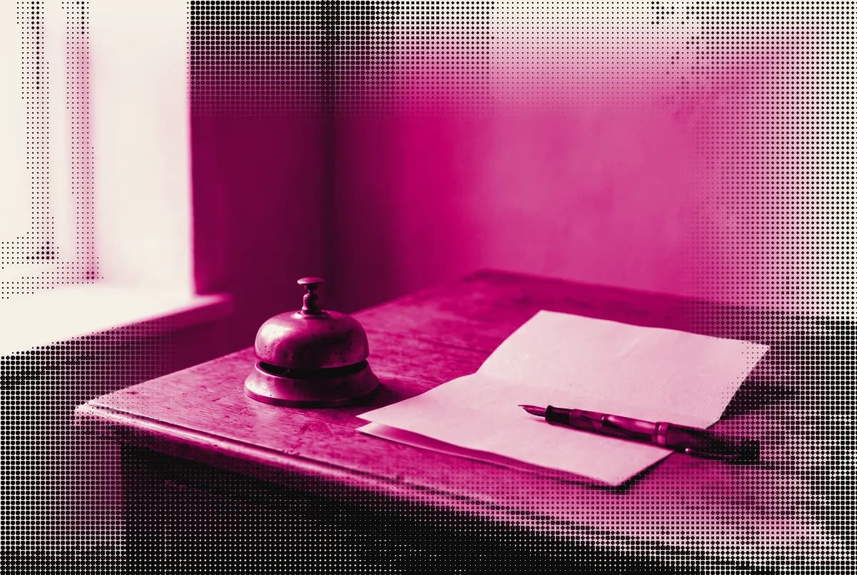 A small brass counter bell on a desk beside a folded sheet of paper and a fountain pen, pressed as a two-ink plate in process magenta