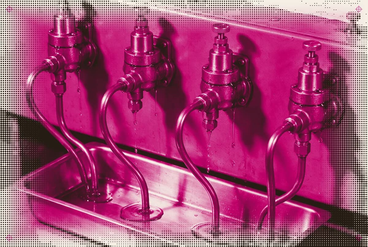 Four leaking brass valves on a pre-digital control bench draining into one tray