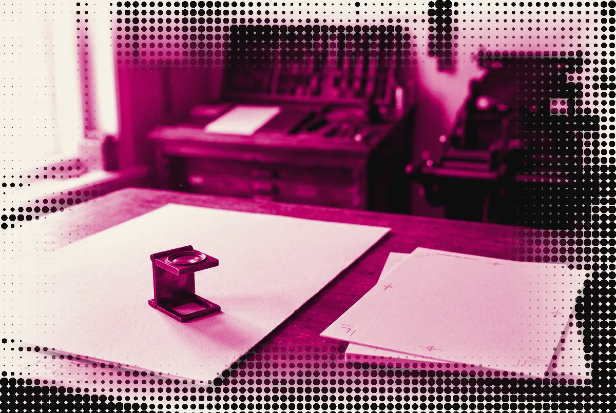 A printer's loupe standing on blank proof sheets in a 1960s print shop, pressed as a two-ink plate in process magenta